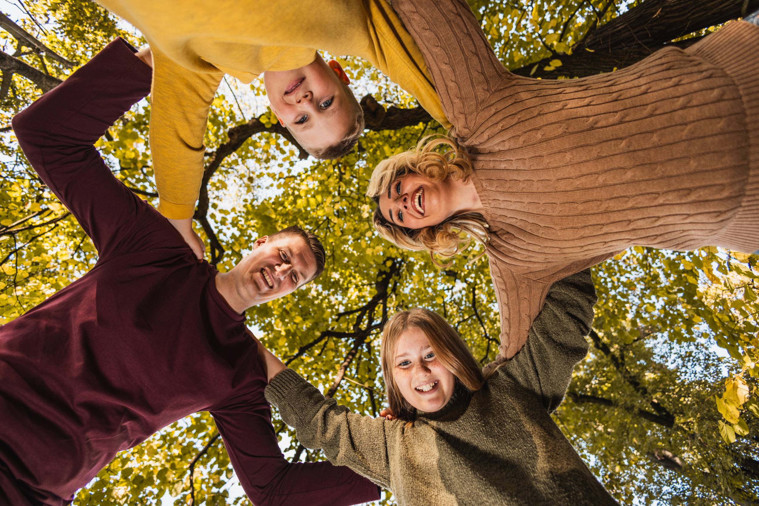 Family Looking Upward Together In Autumn Park